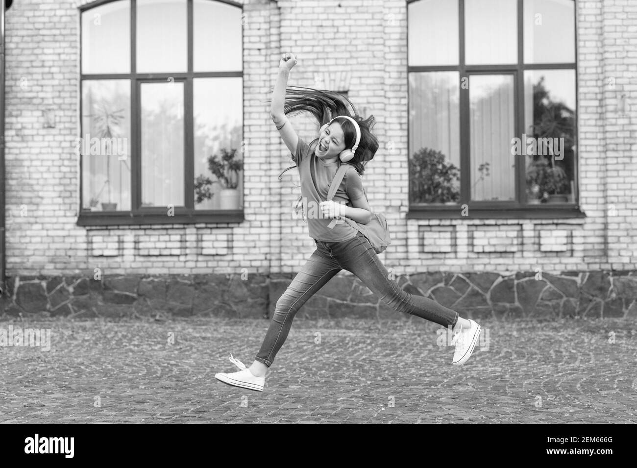 Energetische Kind Mädchen springen tanzen Musik hören Kopfhörer, aktives Leben Konzept. Stockfoto