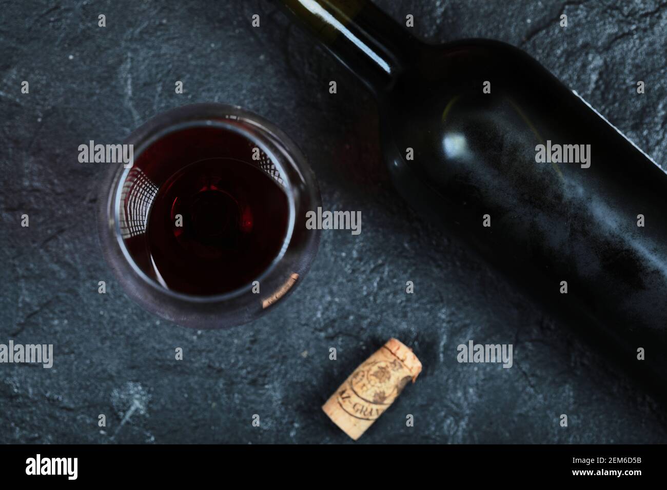 Flasche Wein mit einem Glas Wein im Dunkeln Hintergrund Stockfoto