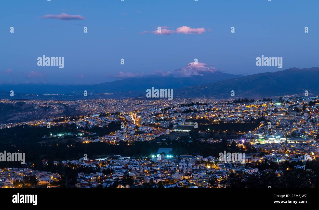 Luftbild blaue Stunde Nacht Stadtbild von Quito mit Vulkan Cayambe, Ecuador. Stockfoto
