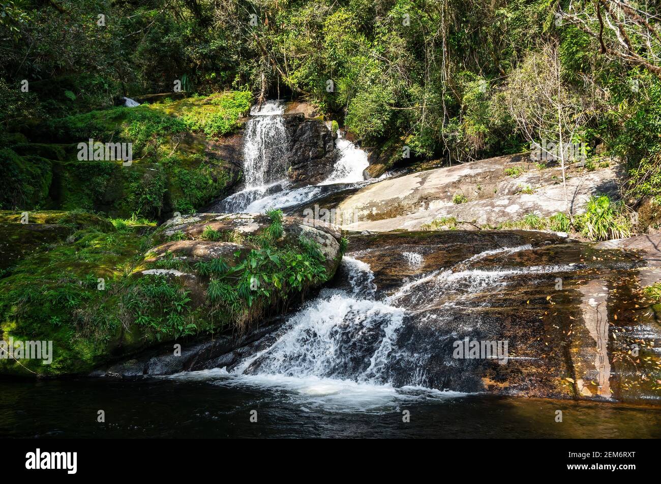 Ipiranguinha Wasserfall mit seiner Wasserströmung fließt um Felsformationen Und die Schaffung eines goldenen natürlichen Pool direkt unten in der Dicht Serra do Mar Stockfoto