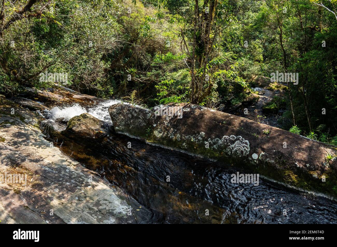 Frische kristallklare Wasserströmung von Ipiranguinha Wasserfall rund über Felsformationen. Dies ist eine der touristischen Attraktionen der Serra do Mar. Stockfoto