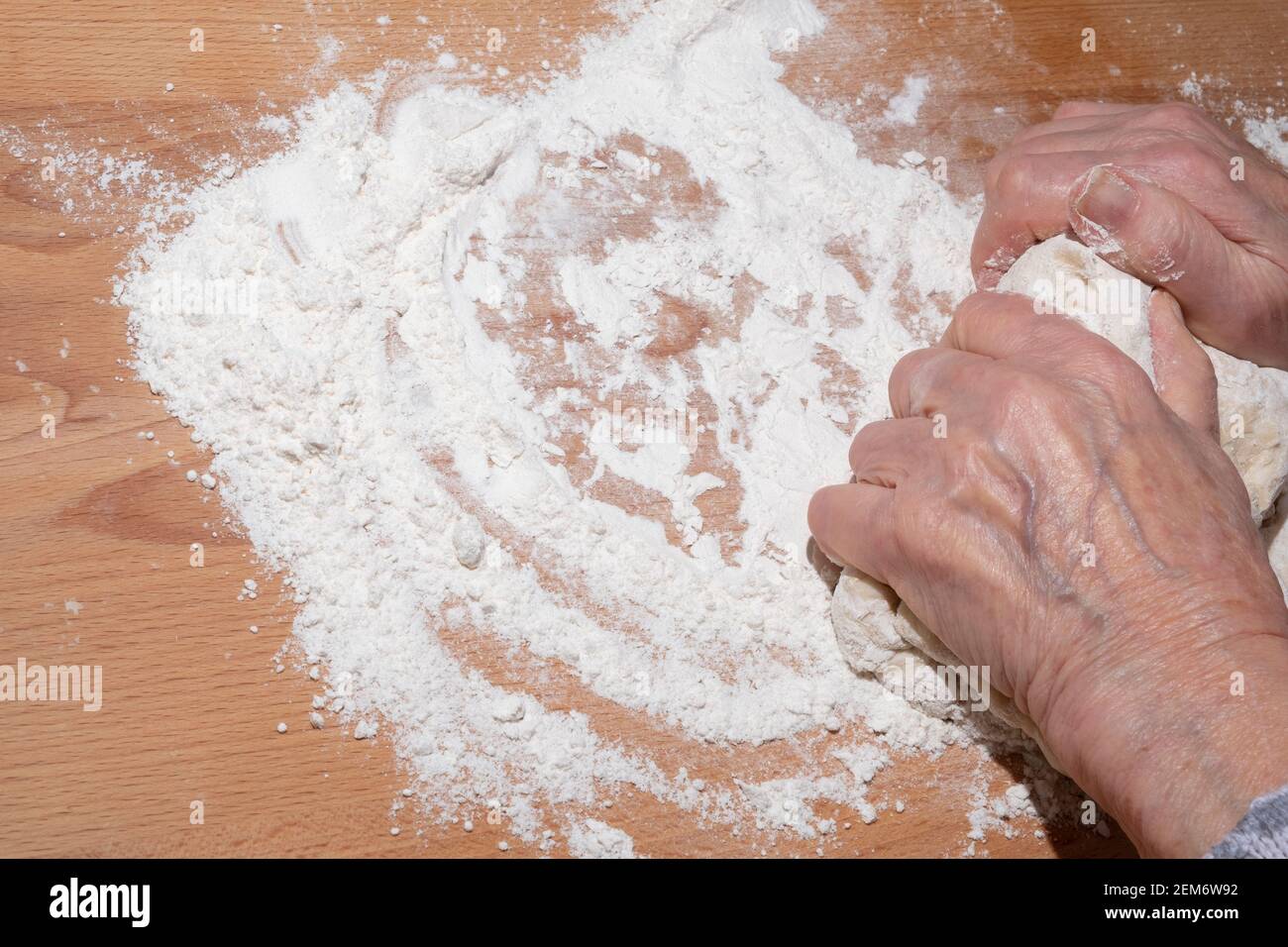 Hände der alten Frau kneten Teig Stockfoto