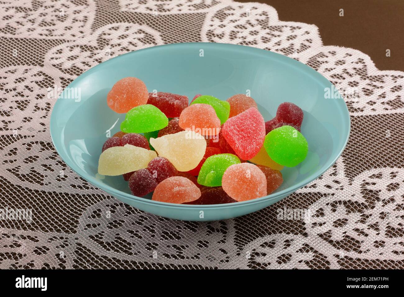 Sommerfrucht Birne, Aprikose, grüner Apfelpfirsich und Wassermelone Saft gefüllt Gummy Süßigkeiten Gelees in blauer Schale auf Spitze Tischläufer auf Tischdecke Stockfoto