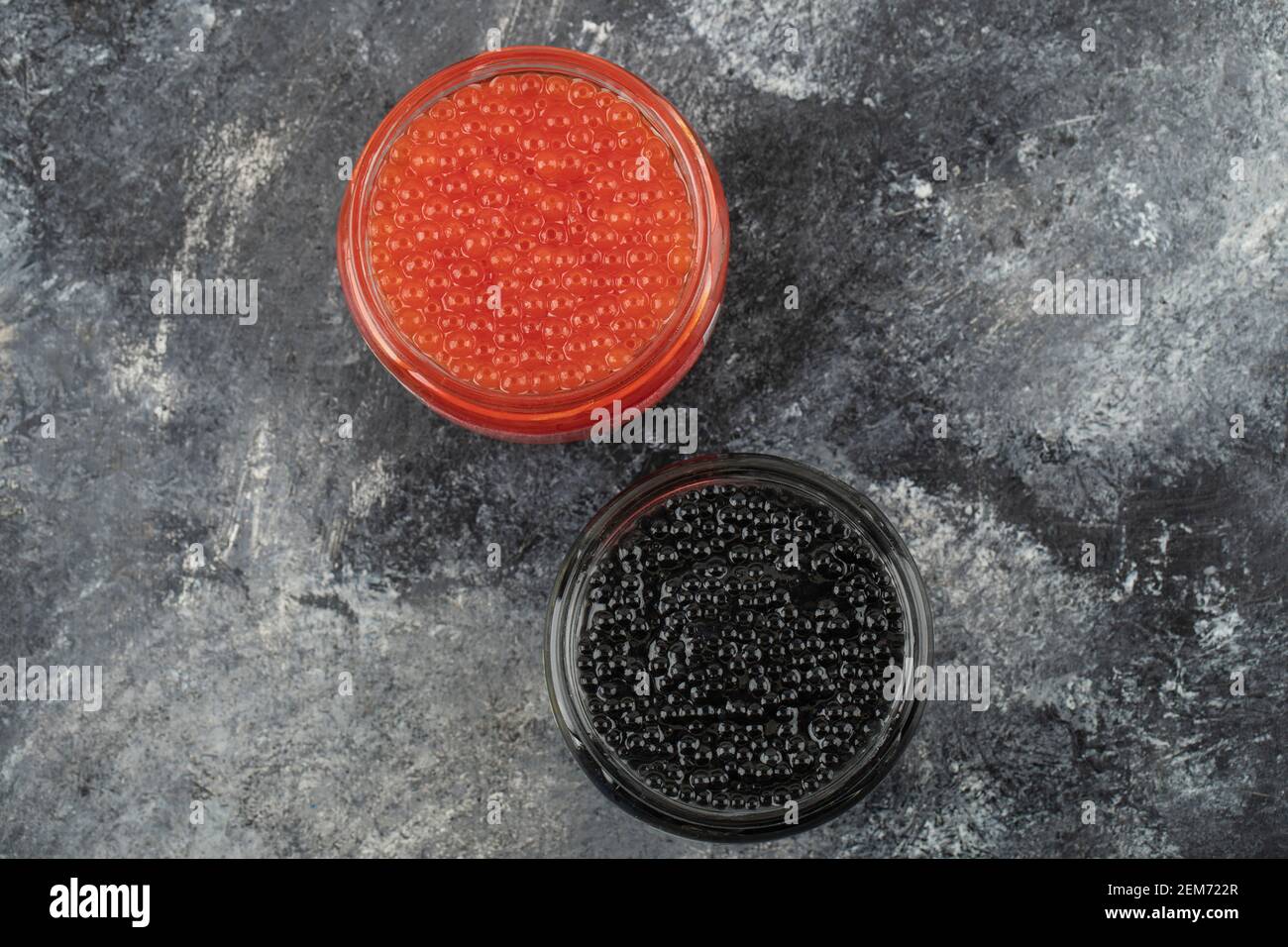 Glasplatten voll von rotem und schwarzem Kaviar auf einem Marmorhintergrund Stockfoto