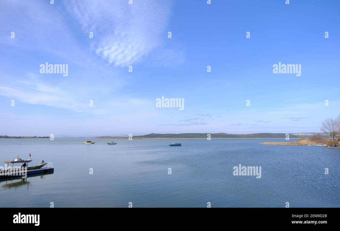 Herrlicher Himmel und Wolkenform auf dem See der Stadt Uluabat in Bursa. Boote auf dem See Teil der Stadt beobachten aus Foto. Stockfoto
