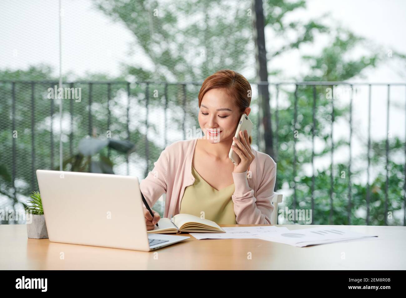 Junge Frau am Telefon im Büro Stockfoto