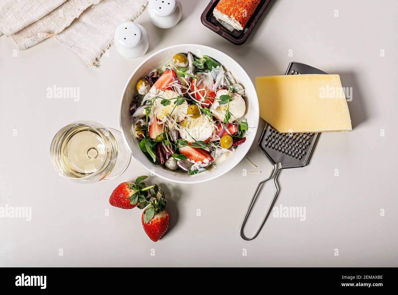 Köstlicher Salat mit frischen Erdbeeren, roten Zwiebeln, Kräutern, Ziegenkäse und Oliven. Essen Stillleben auf einem hellen Hintergrund. Bio-Landwirtschaftsprodukte. Heilen Stockfoto