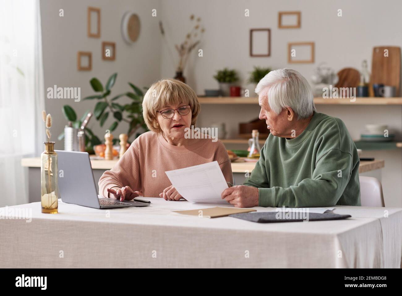 Ältere Paare sitzen am Tisch mit Laptop und arbeiten Mit Finanzdokumenten zu Hause Stockfoto