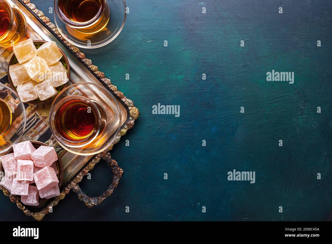 Tee in traditionellen Glas-Tassen und türkischen Delight auf dunkelblau-grün bemalten Holzhintergrund mit leerem Platz für Text . Flach liegend. Stockfoto