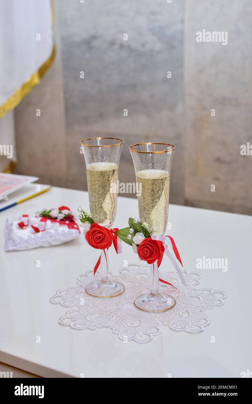 Hochzeit Champagner Gläser sind mit Rosenblumen auf dem Tisch dekoriert. Hochzeitszeremonie. Vertikales Foto. Stockfoto