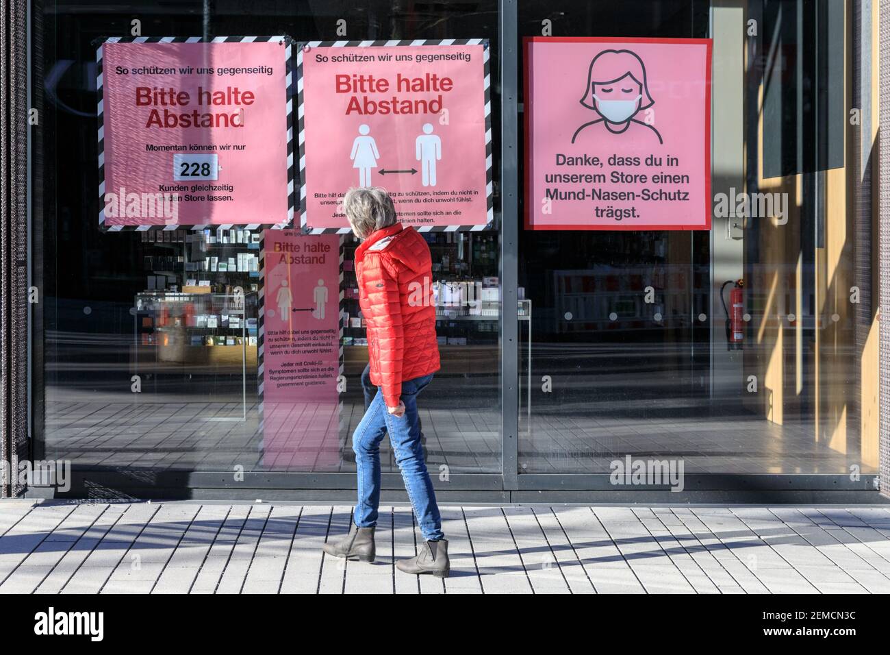 Eine Frau schaut auf ein Schaufenster mit sozialer Distanzierung und Maskentrageregeln, Düsseldorf, Deutschland Stockfoto