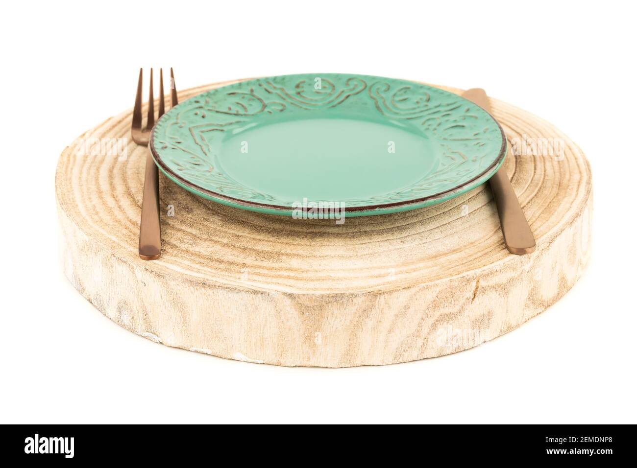 Grüner Teller mit Messer und Gabel auf Holzbrett isoliert auf weißem Hintergrund. Stockfoto