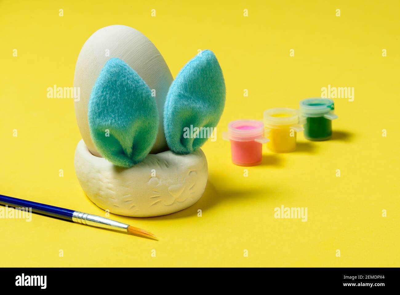 Ostereier Malset mit Hase. Pinsel und Farben auf gelbem Hintergrund Stockfoto