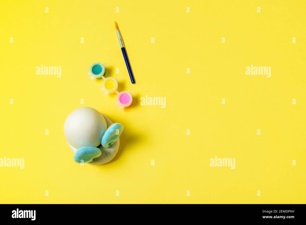 Ostereier Malset mit Hase. Pinsel und Farben auf gelbem Hintergrund Stockfoto