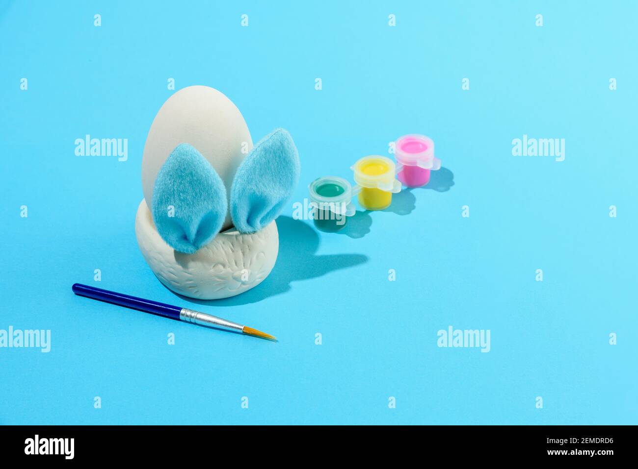 Ostereier Malset mit Hase. Pinsel und malt auf hellblauem Hintergrund Stockfoto