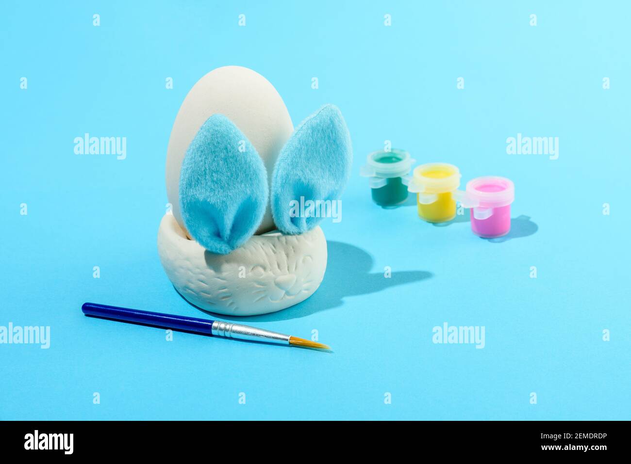 Ostereier Malset mit Hase. Pinsel und malt auf hellblauem Hintergrund Stockfoto