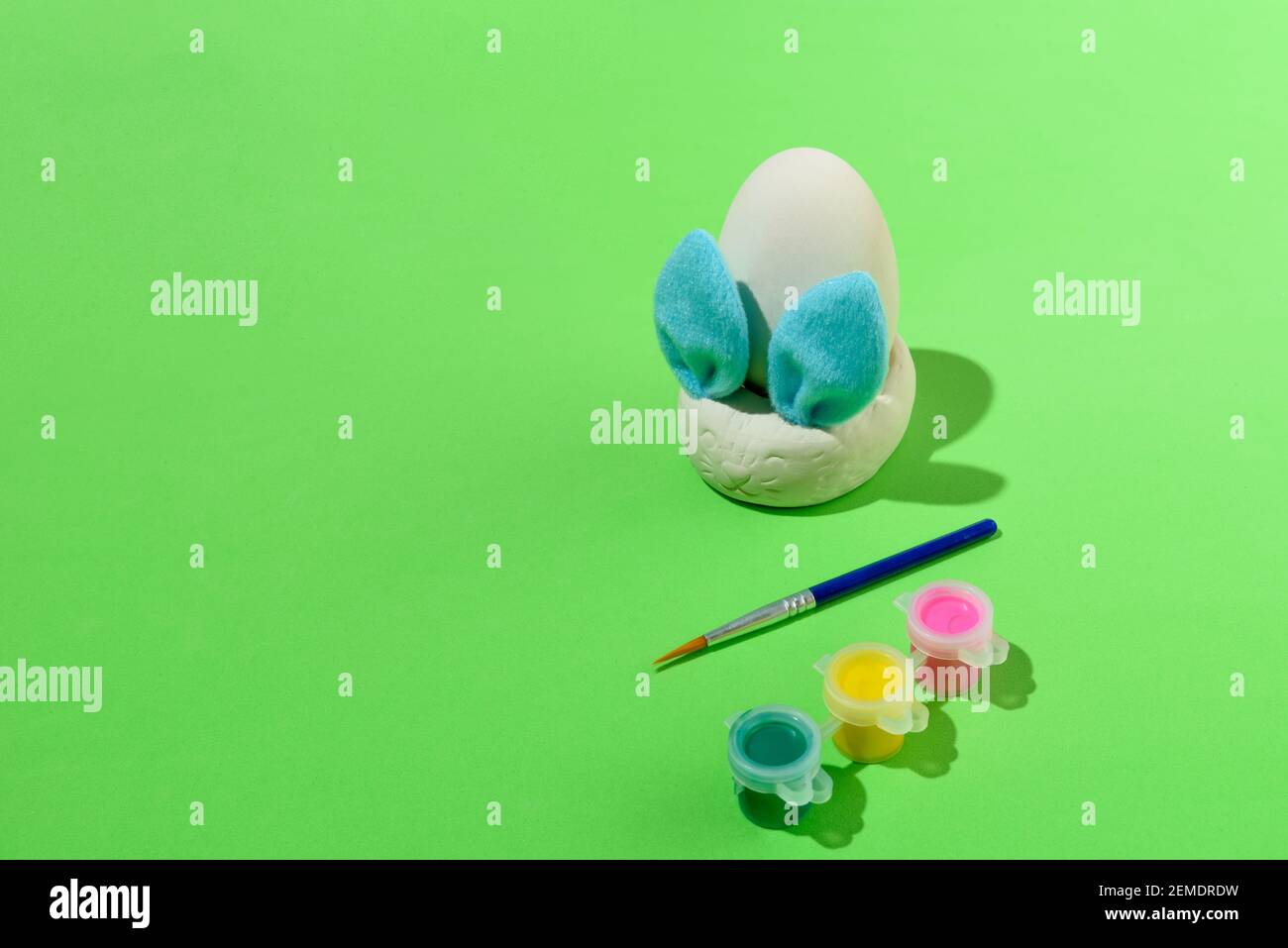 Ostereier Malset mit Hase. Pinsel und Farben auf grünem Hintergrund Stockfoto