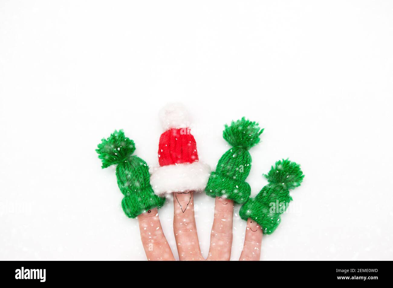 Glückliche Familie mit den Fingern in warmen Hüte Santa und elf auf weißem Hintergrund Stockfoto