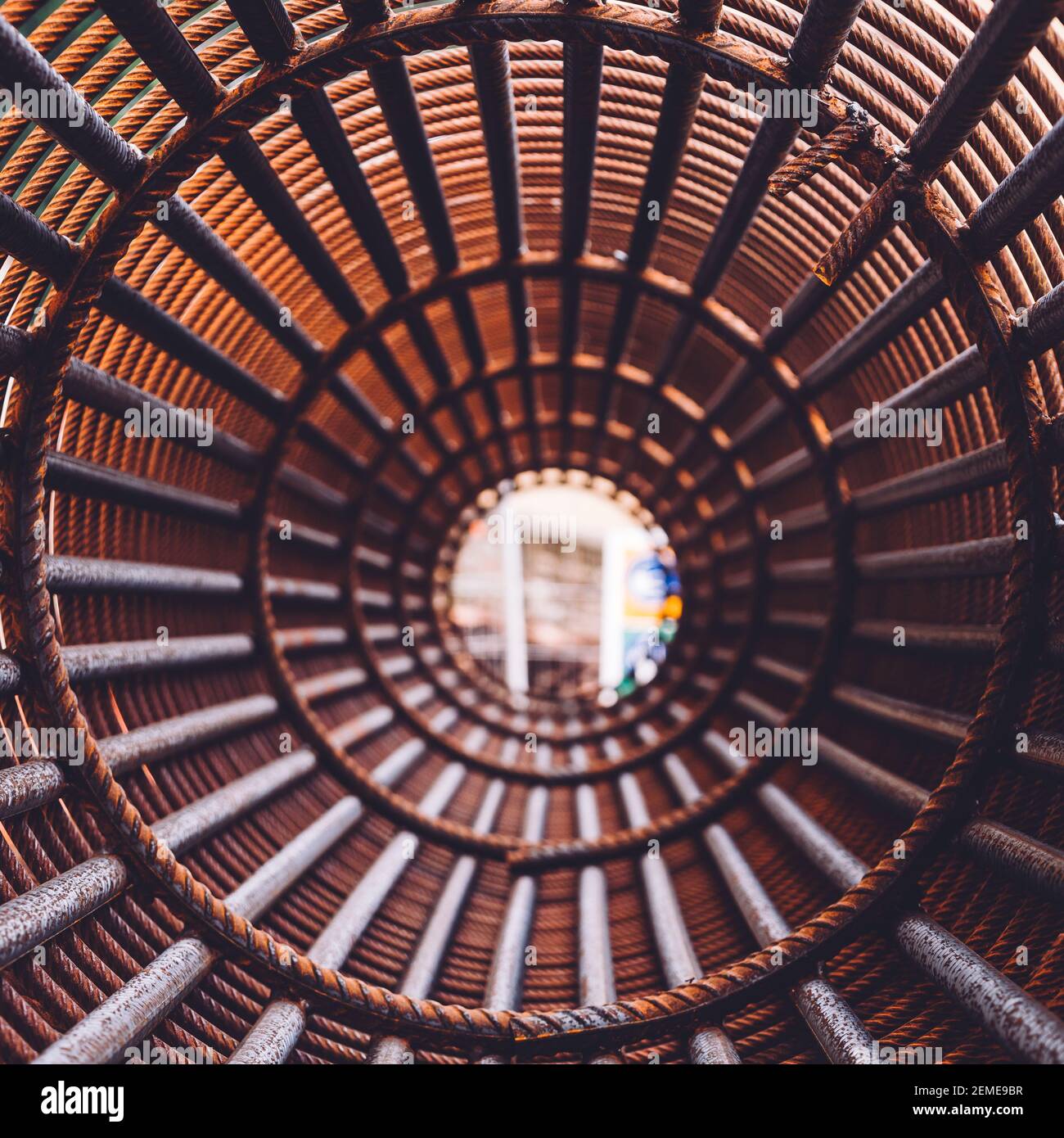 Bügeleisen auf der Baustelle. Rosty Circle Iron Bundle für die Herstellung von Stahlbeton und Kunststoff orange Netz. Innenansicht des Rebars für verstärktes Loch Stockfoto