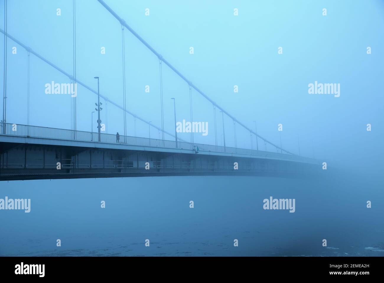 Elisabethbrücke im geheimnisvollen Nebel über der eisigen Donau in Budapest, Ungarn; Farbfoto Stockfoto