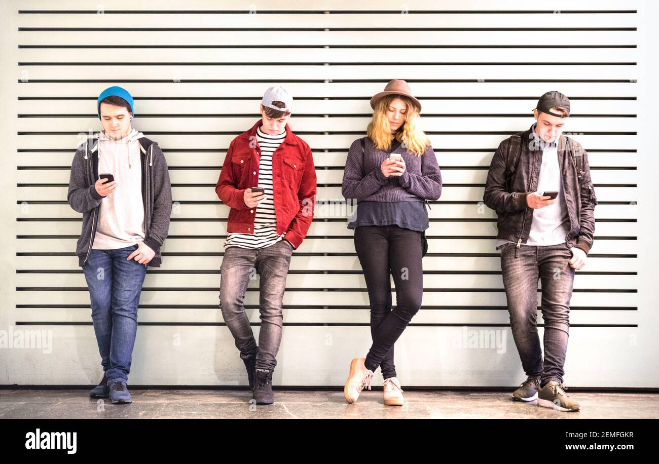 Freunde Gruppe mit Smartphone gegen Wand an der Universität College Hinterhof Pause - Junge Menschen süchtig nach Handy - Technologiekonzept Stockfoto