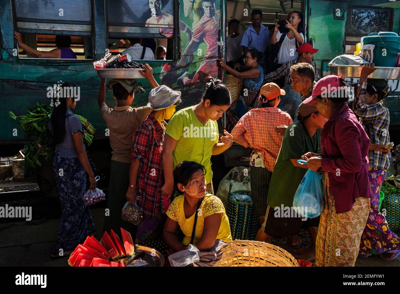 Passagiere, die an einem der Bahnhöfe in Yangon, Myanmar, in den Zug einsteigen und dort abfahren. Stockfoto