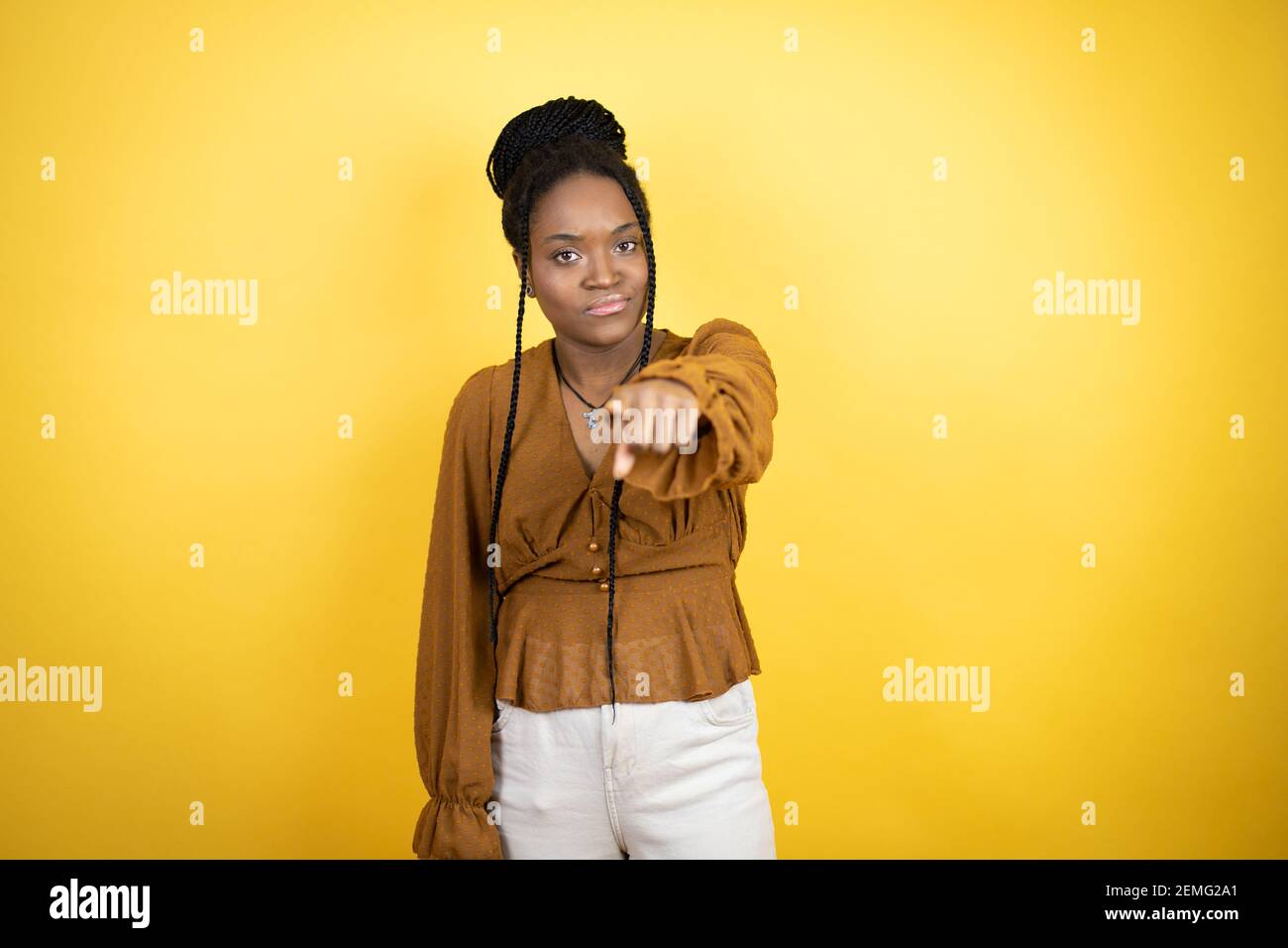 afroamerikanische Frau trägt legere Kleidung, die mit dem Finger auf die Kamera und Sie, selbstbewusste Geste, die ernst Stockfoto