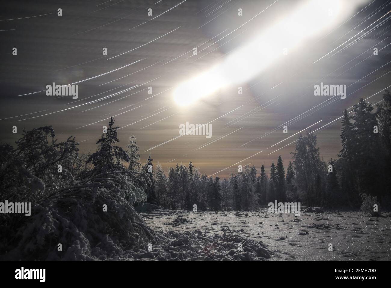 Langausstrahlung Sternspur Aufnahme von winterlicher Wiese mit Mond. Stockfoto