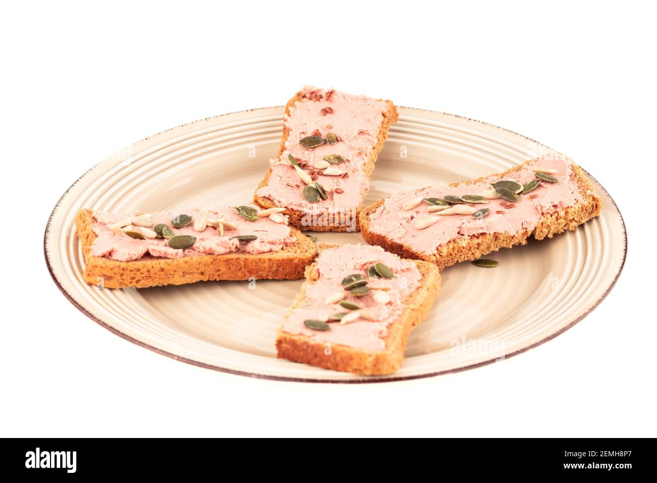 Sandwiches mit Pastete und Samen auf Teller isoliert auf weißem Hintergrund. Stockfoto