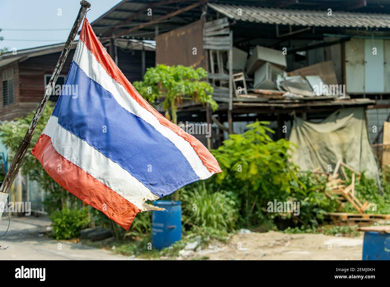 Die Nationalflagge Thailands flattert auf der Straße am Stadtrand. Stockfoto