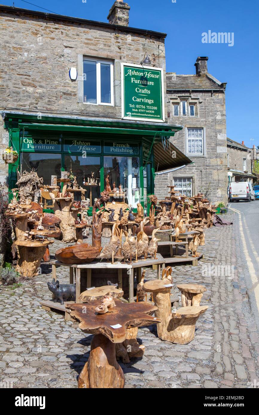 Eine Ausstellung von geschnitzten Holzobjekten, Souvenirs und Möbeln vor Ashton House, ein Geschäft auf der Main Street, Grassington, North Yorkshire Stockfoto