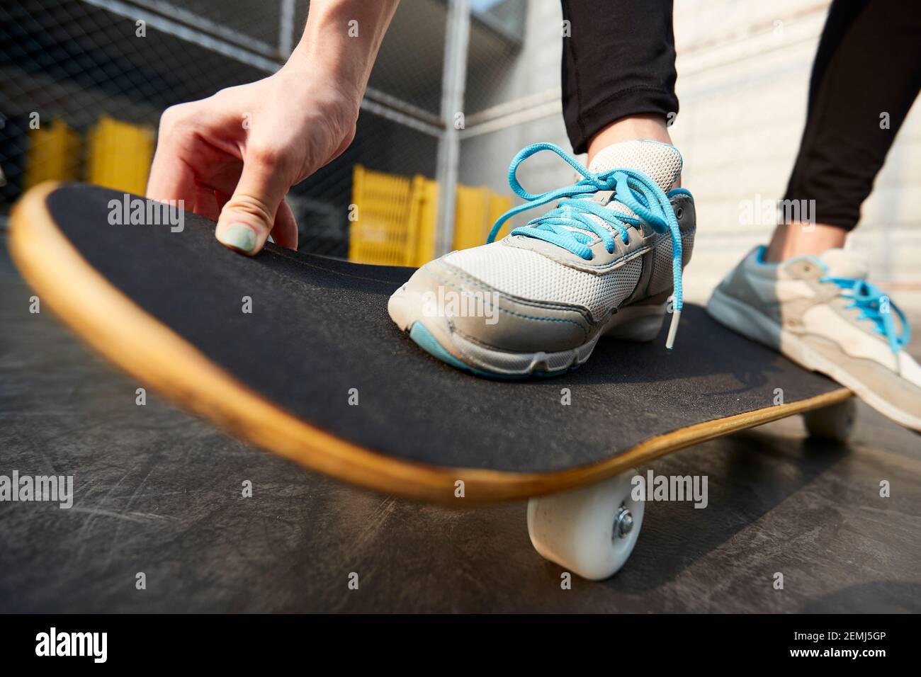 Nahaufnahme der Füße einer jungen asiatischen Frau, die draußen Skateboarding Stockfoto