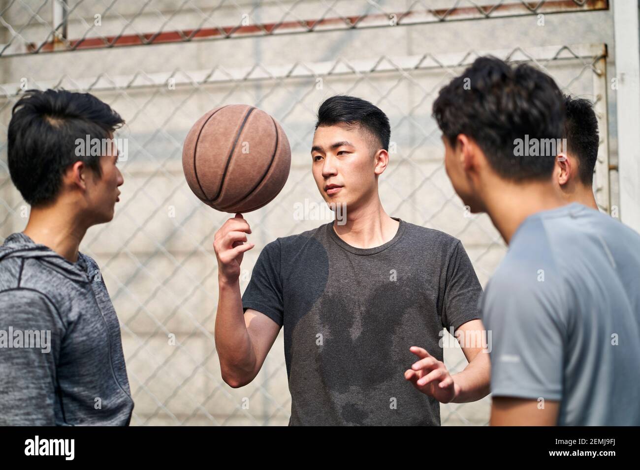 Junge asiatische Erwachsene Männer mit Spaß spielen mit Basketball im Freien Stockfoto