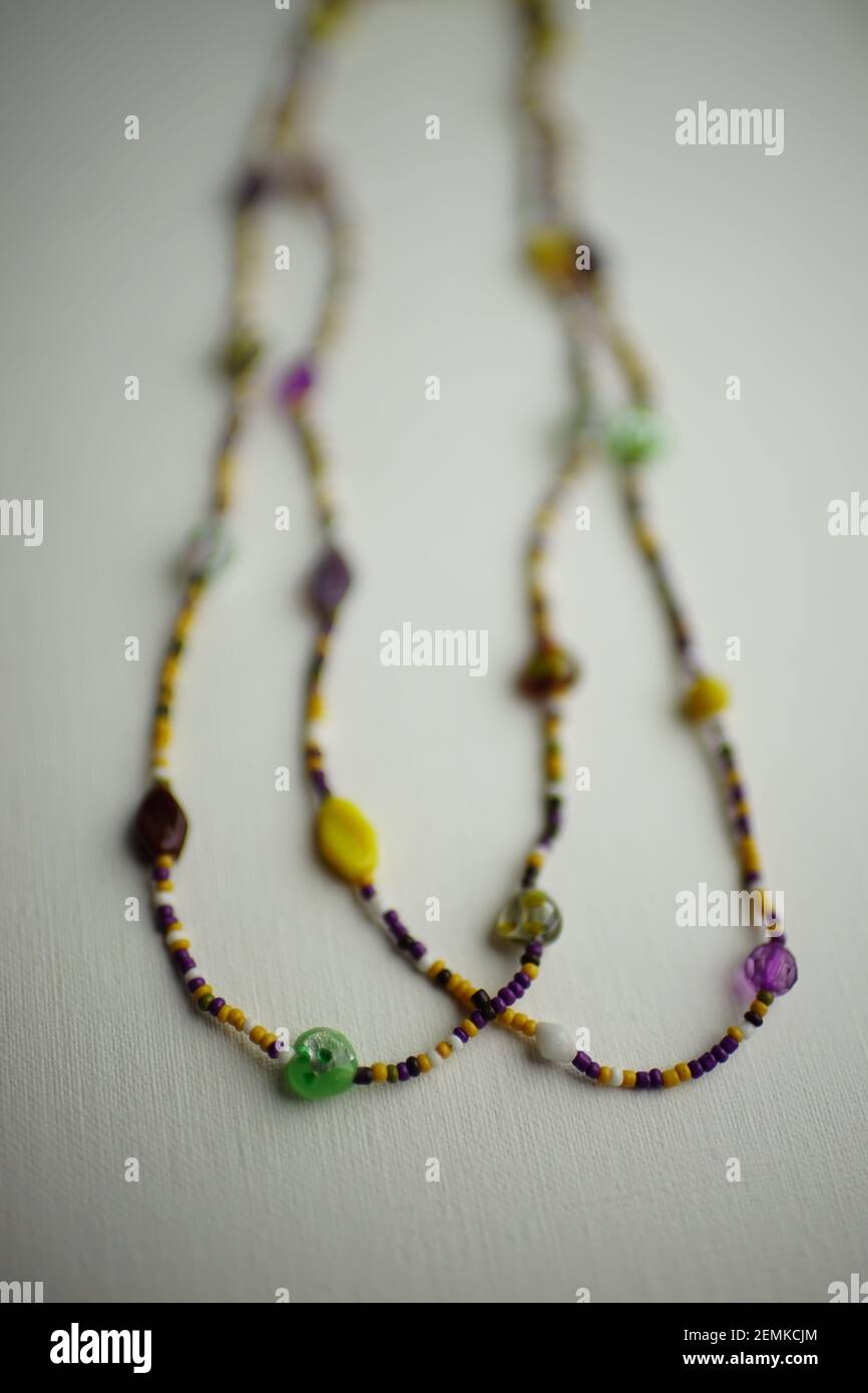 Perlen aus Perlen und verschiedenen Steinen auf einem weißen Textur-Tisch. Stockfoto