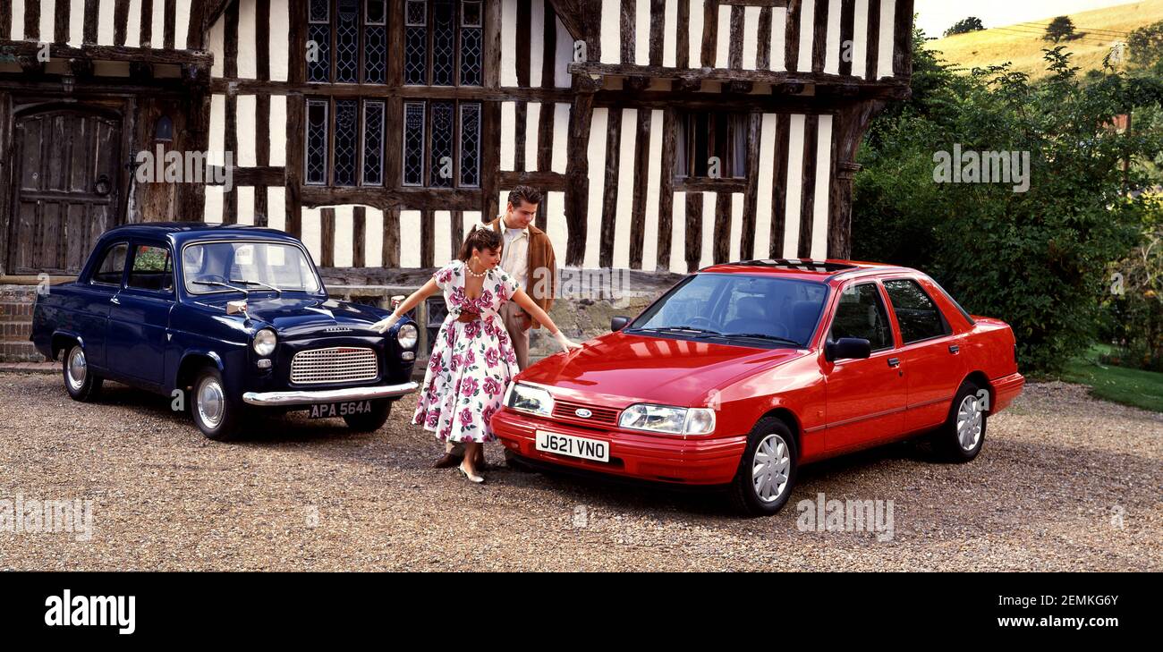 50er Jahre junges Paar mit Ford Saloon's, a1963 Ford Präfekt mit 1991 Ford Sierra Stockfoto