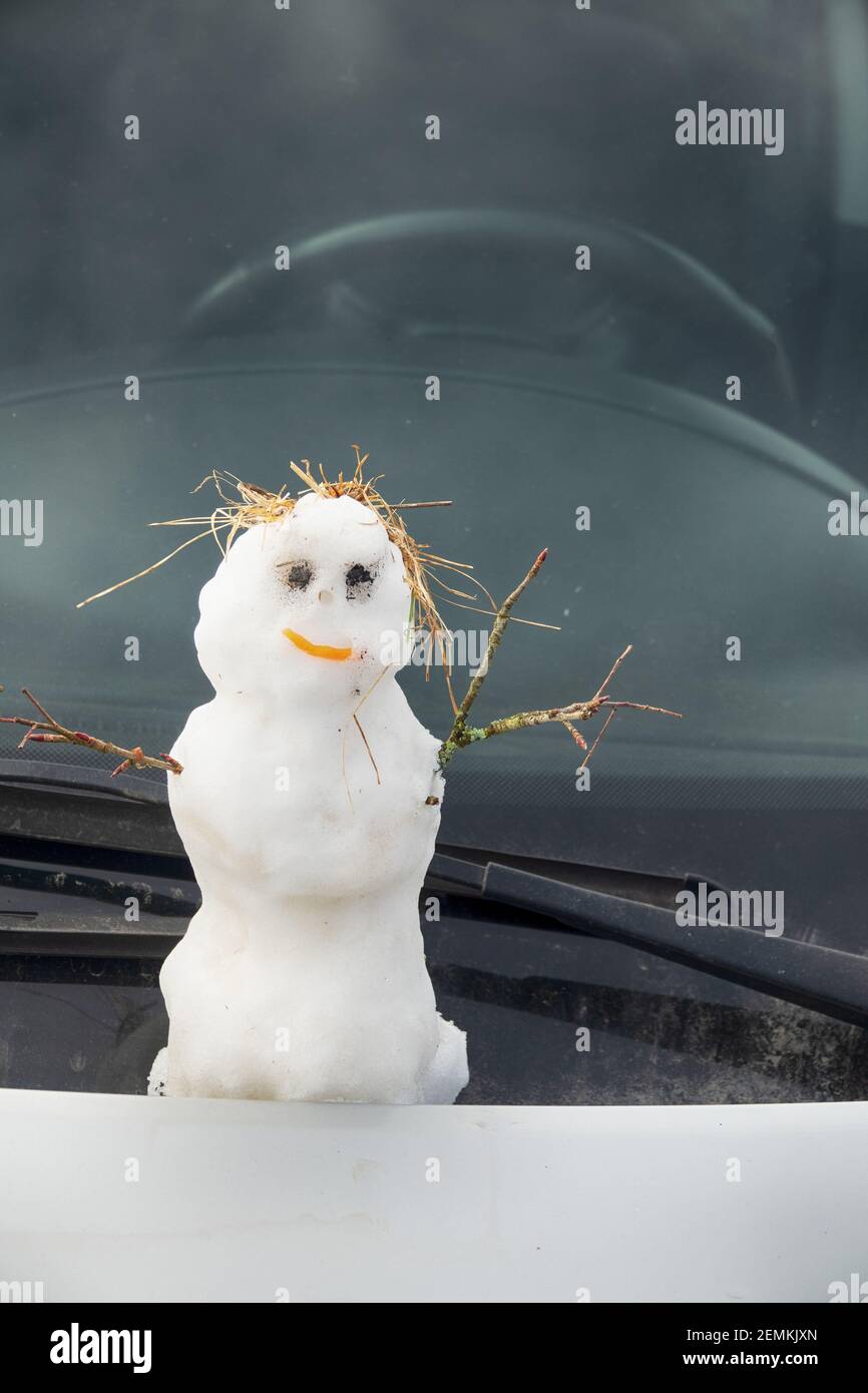 Schneemänner auf der Windschutzscheibe eines Autos. Frohe Weihnachten und ein glückliches Neues Jahr an alle, die hinter dem Steuer fahren Stockfoto