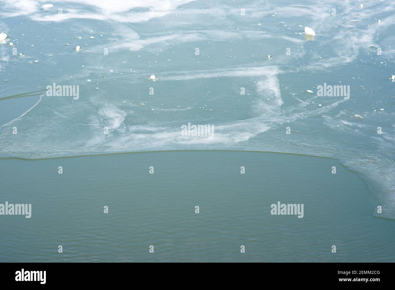 Eine Wasseroberfläche, die teilweise mit Eis bedeckt ist Stockfoto