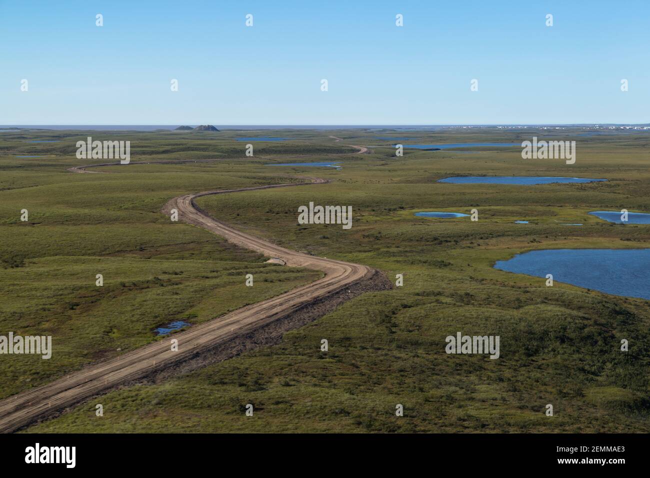 Luftaufnahme des 139km Allwetter-Kieses Inuvik-Tuktoyaktuk Highway mit Pingos in der Ferne, Nordwest-Territorien, Kanadas Arktis. Stockfoto