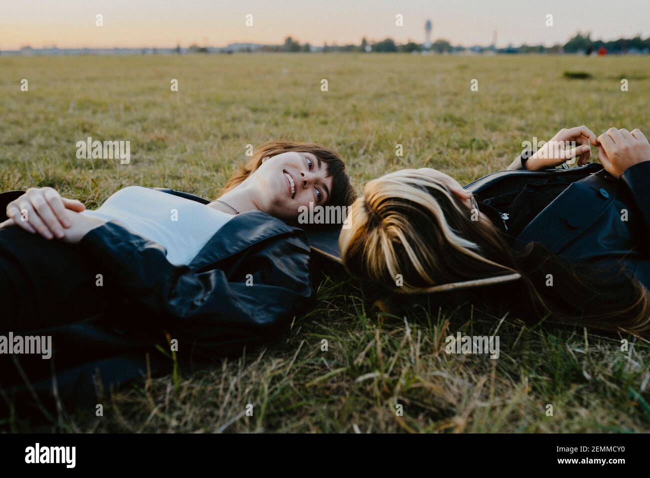 Junge Freundinnen liegen auf Gras im Park Stockfoto