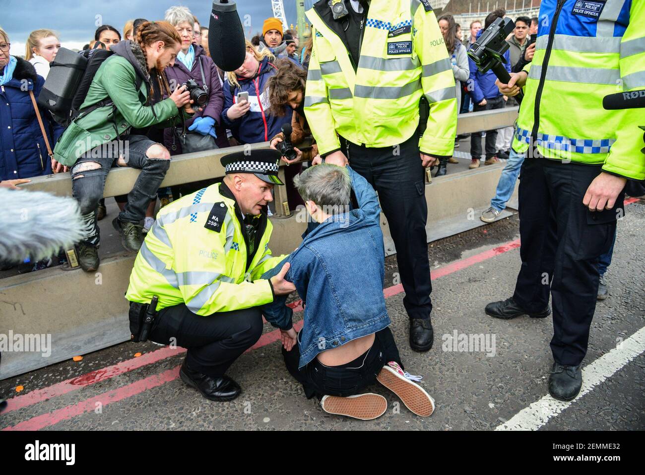 Polizeibeamte bitten einen Studenten mehrmals aufzustehen und zu einem Polizeiwagen zu gehen, nachdem er verhaftet wurde.Er weigert sich zu antworten.Dies folgt einem Protest der studentischen Klimaaktivisten Westminster Bridge in London, Großbritannien am 15. März 2019. Schüler gehen heute in den USA in einen Streik und fordern mehr Maßnahmen gegen den Klimawandel. (Foto von Claire Doherty/Sipa USA) Stockfoto