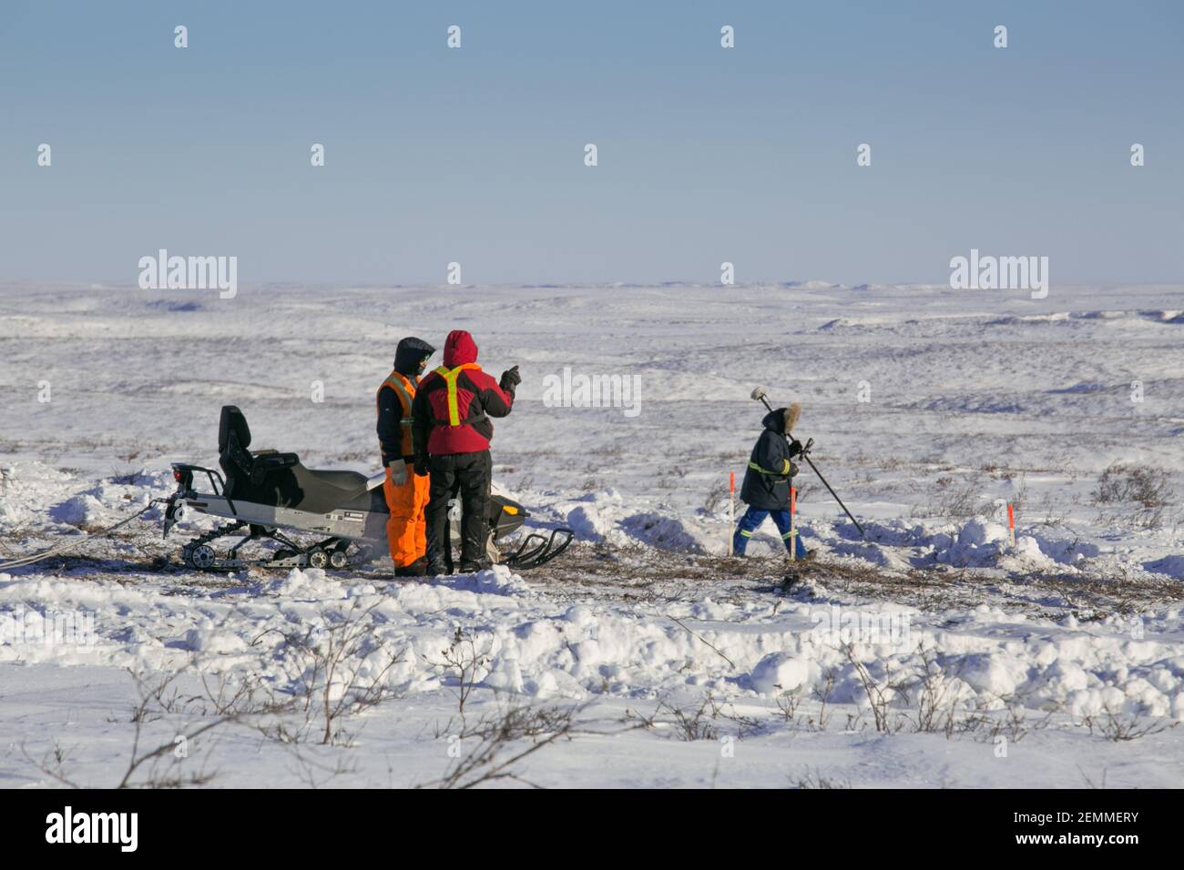 Vermesser bei der Arbeit an der gefrorenen Tundra während des Winterbaus des Inuvik-Tuktoyaktuk Highway, Northwest Territories, Kanadas Arktis. Stockfoto