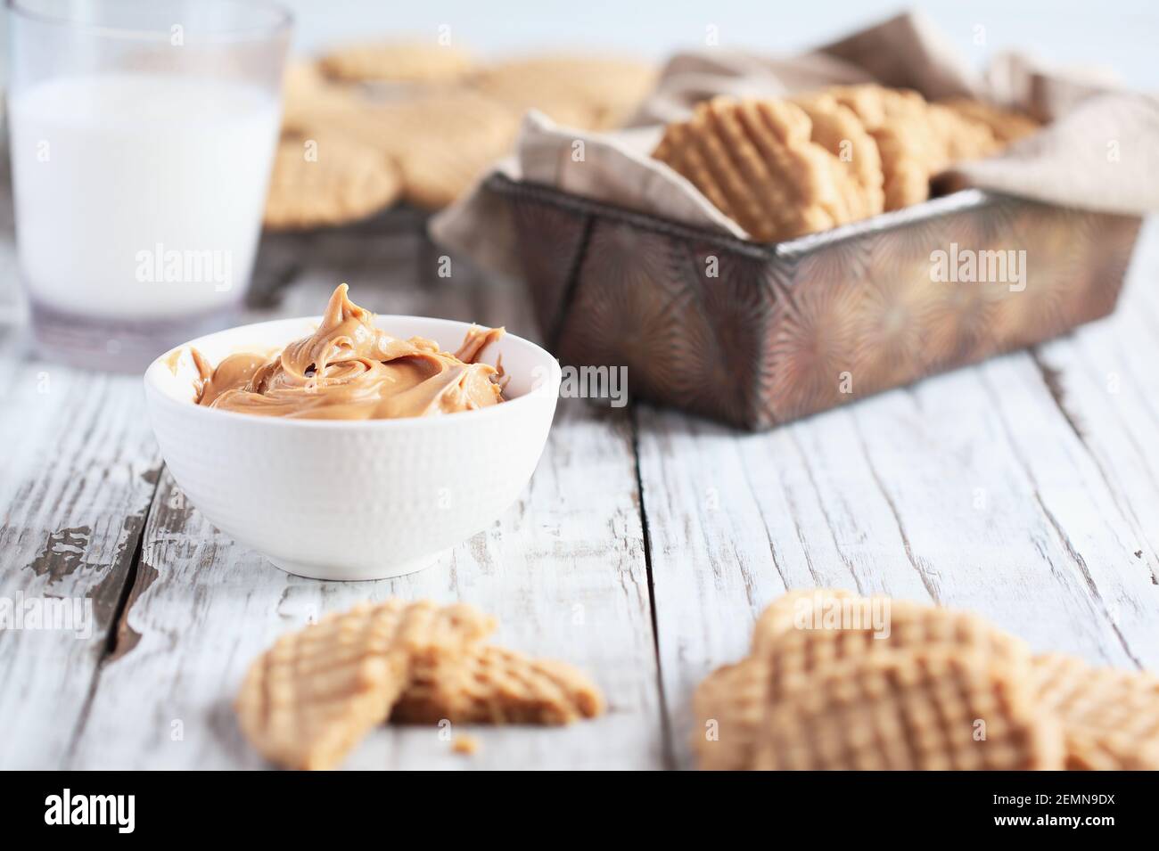 Schüssel cremige Erdnussbutter mit frisch gebackenen, hausgemachten Plätzchen. Selektiver Fokus auf Ausbreitung in der Mitte mit verschwommenem Vorder- und Hintergrund. Stockfoto