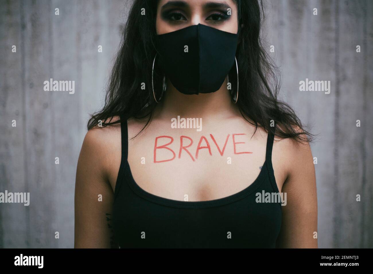 Aktivistin mit tapferen Text auf der Brust gegen die Wand geschrieben Während einer Pandemie Stockfoto