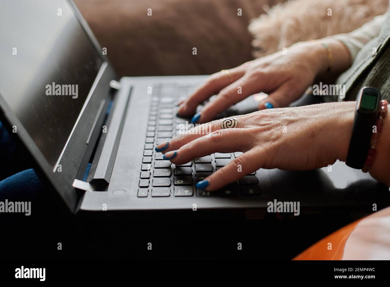 Nahaufnahme einer Frau mittleren Alters, die aus der Ferne mit ihrem Laptop arbeitet Stockfoto