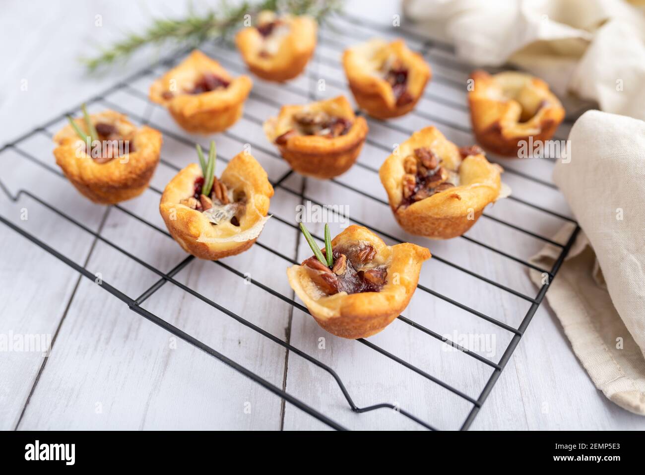 Brie beißt mit Marmelade und Nüssen in Halbmondteig, Mini-Vorspeise Dessert mit Preiselbeere oder Gelee Stockfoto