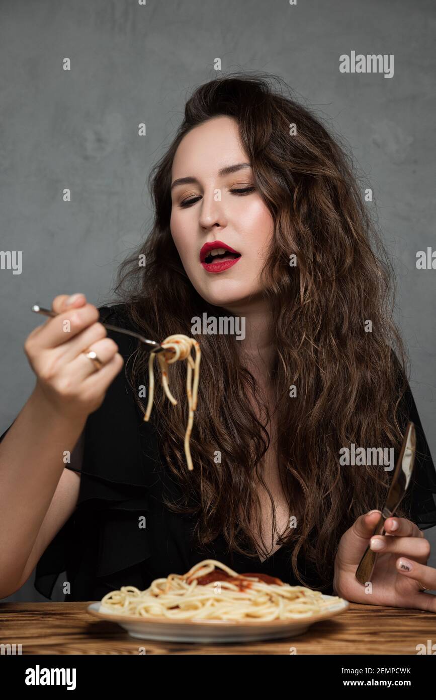 Eine schöne junge Frau isst italienische Spaghetti Pasta Stockfoto