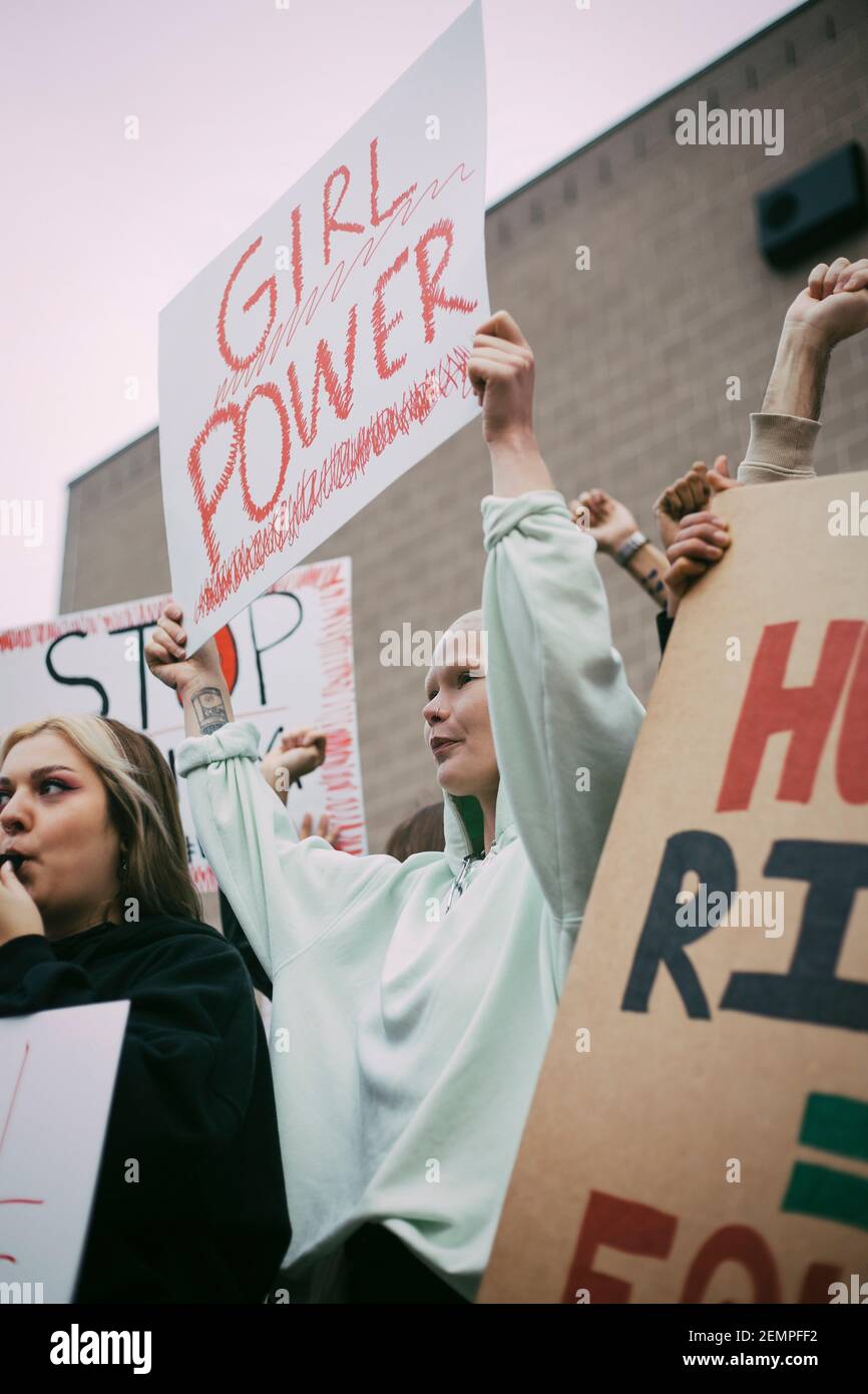Junge weibliche Demonstranten mit Mädchen Macht Schild in der sozialen Bewegung Stockfoto