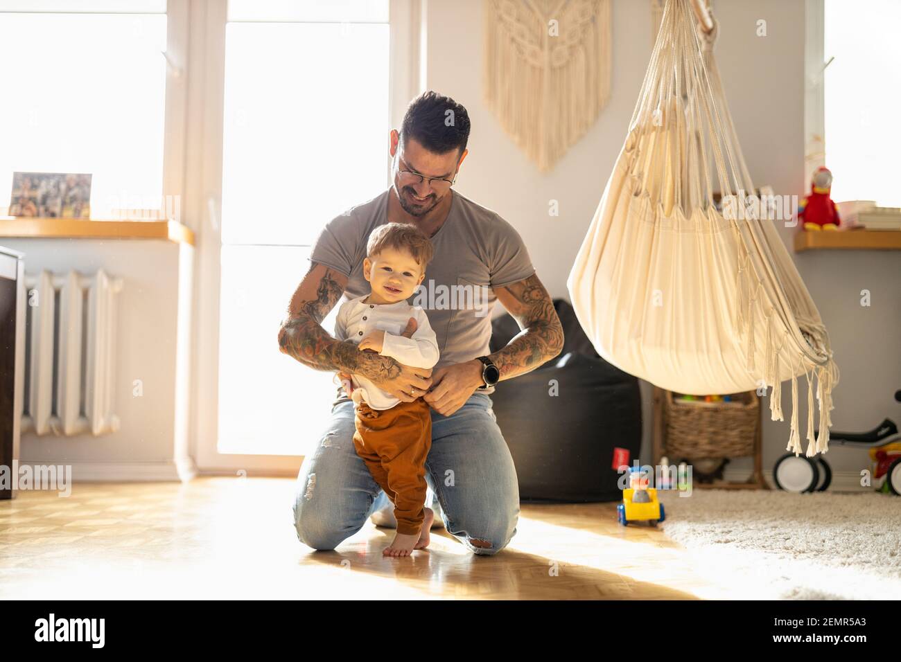 Vater, der sich zu Hause um seinen kleinen Sohn gefreut hat Stockfoto