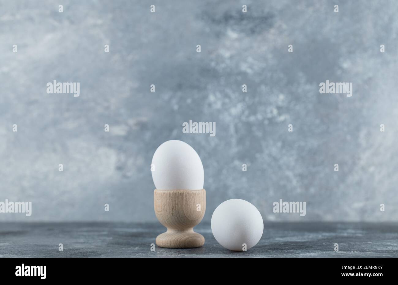 Eierbecher und Eier auf grauem Hintergrund Stockfoto