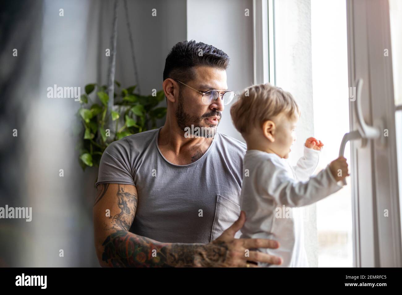 Vater, der sich zu Hause um seinen kleinen Sohn gefreut hat Stockfoto